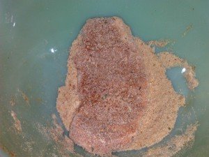 pork chop in bowl of bread crumbs