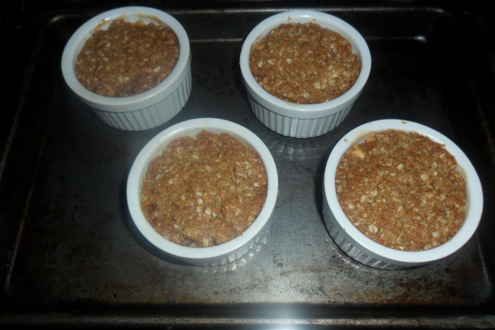 Four ramekins of apple cobbler