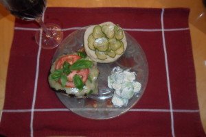 place setting with prepared mushroom burger, cucumber salad, and glass of wine