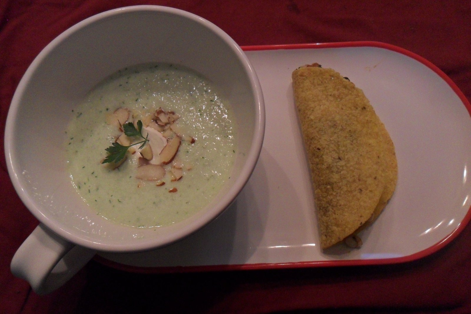 Garnished Cucumber soup on plate with vegie taco