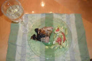 grilled chicken on plate with salad and a glass of wine