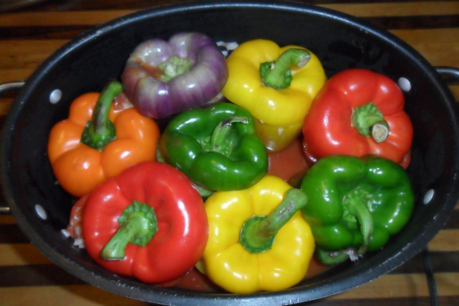 Green, yellow, red, orange, and purple peppers in the pot