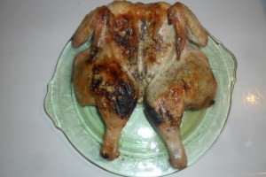 Grilled butterflied whole chicken on serving plate