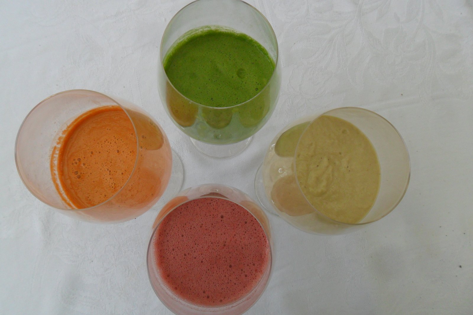 green, orange, purple, and yellow juice and smoothie drinks