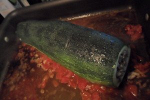 Whole zucchini in pan with tomatoes