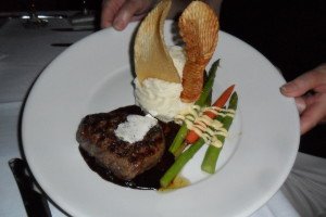 filet with asparagus and potatoes decorated with two giant waffle fries