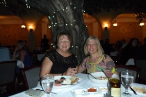 Us two ladies at our dinner table with a lit tree behind us.