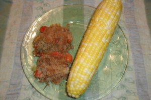 Cherry tomato casserole served with a giant corn on the cob