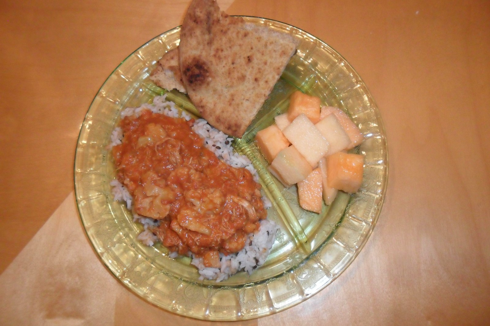 Tikki masala on rice with melon and naan bread