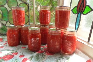 Bright jars of tomatoes in front of stained glass windows