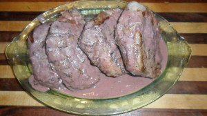 Platter with lamb steaks covered in rosemary wine sauce.