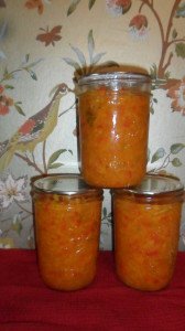 Three beautiful relish jars in front of funky peacock wallpaper