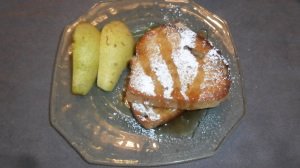 Stuffed French Toast dusted with powdered sugar and served with pear slices.