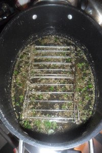 Herbs whisked into water under the rack.