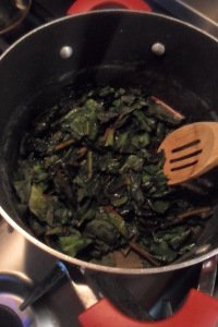 The green leaves steaming in a pan.