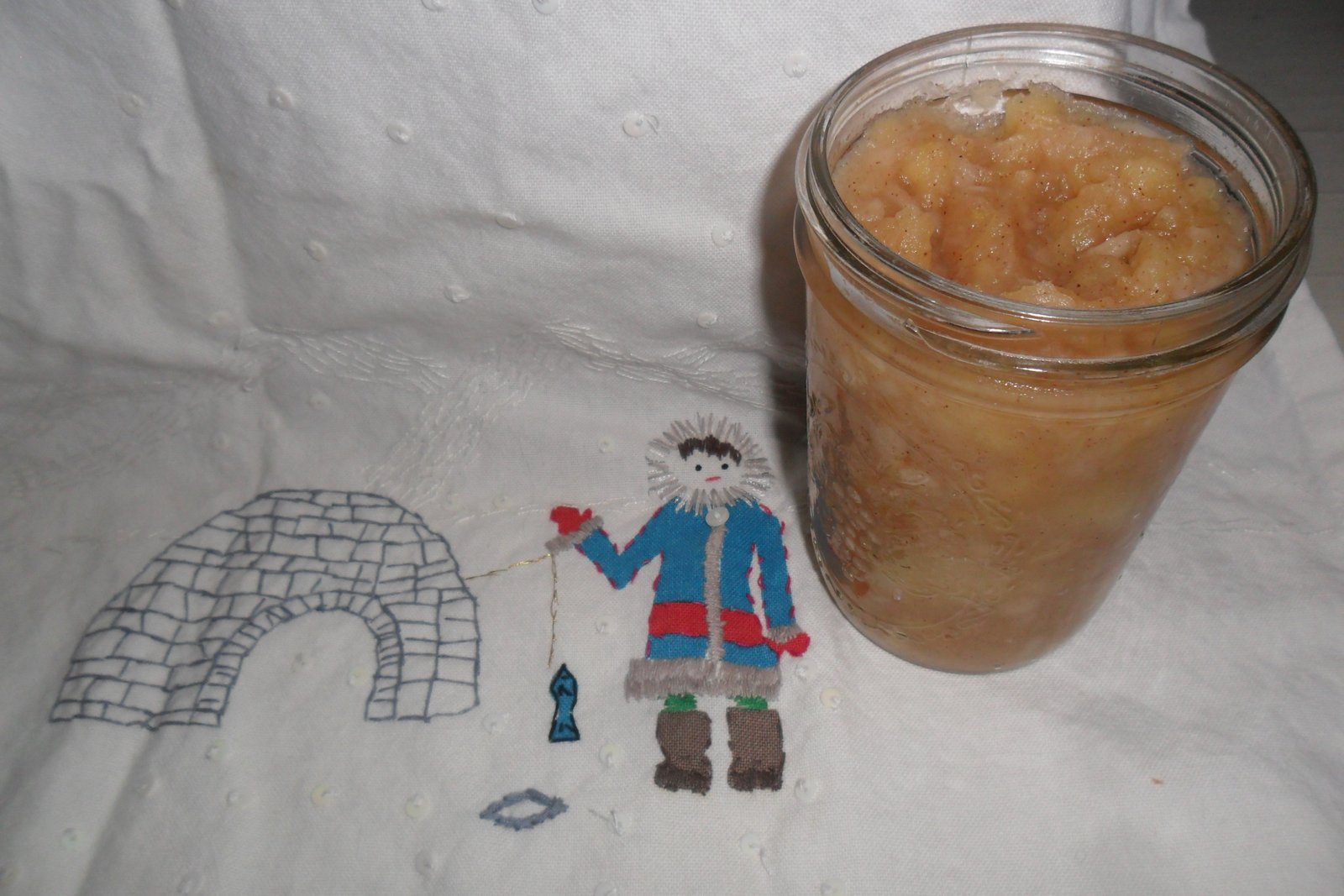 Jar of homemade applesauce on ice-fishing dish towel