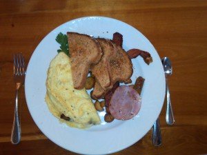 omelet with thick fresh toast and meats.