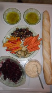 Colorful arrangement of relishes, dips, fruits, vegetables, bread, and dips.