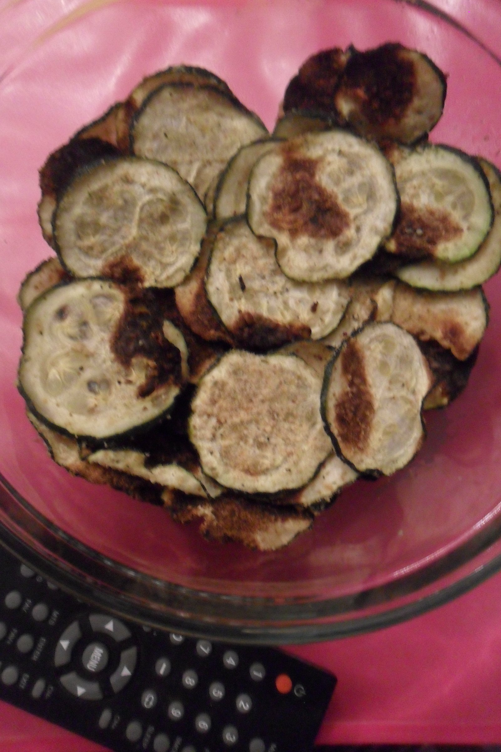 Zucchini chips in a bowl next to the remote.