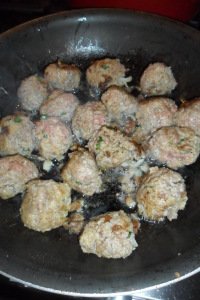 Meatballs browning in pan