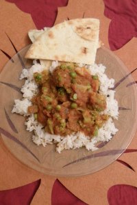 Vegetable curry served on rice with naan bread.