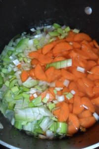 The vegies cooking in a pot with the liquids