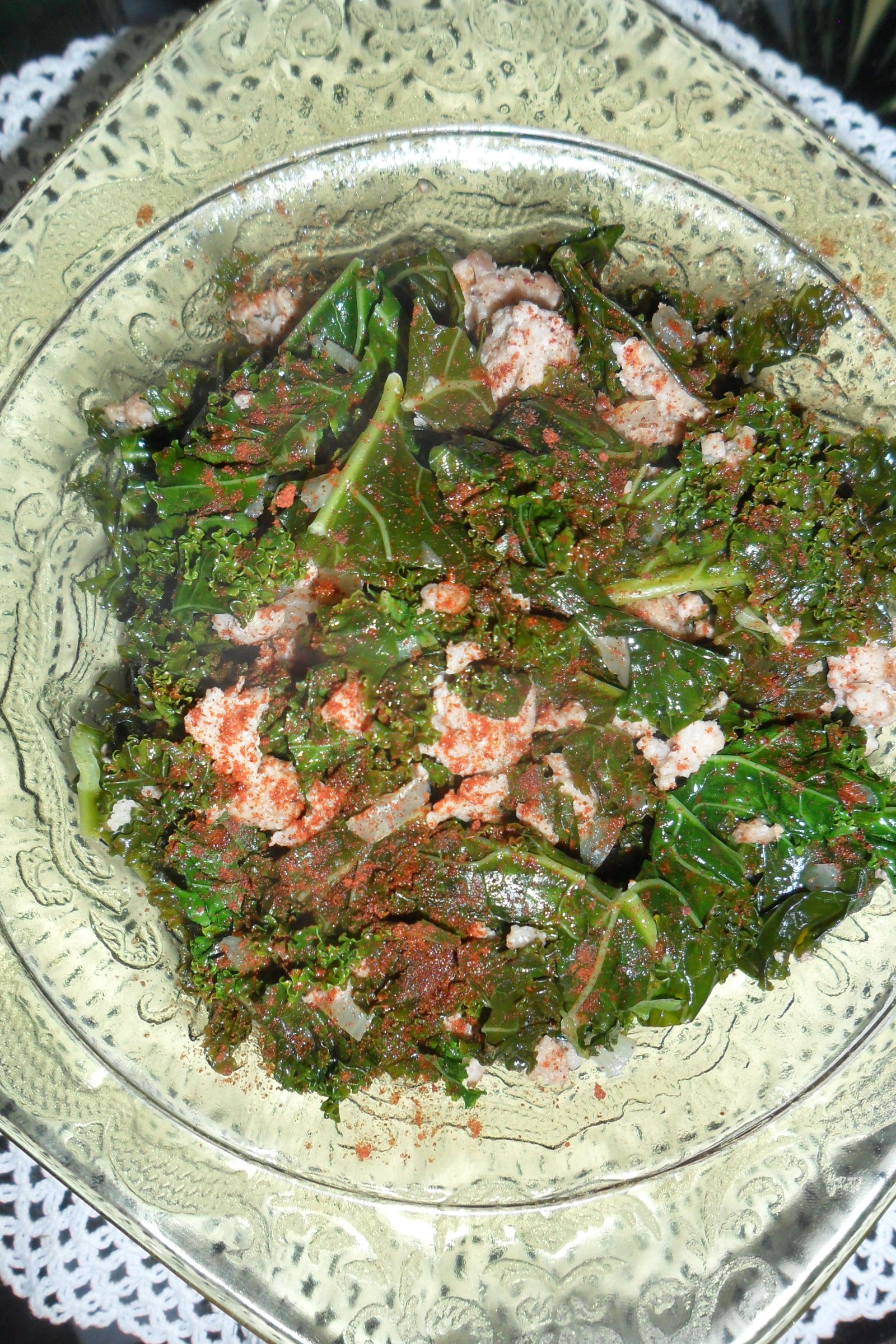 Serving kale and pork with paprika garnish