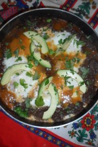 Garnished chilaquiles in pan.