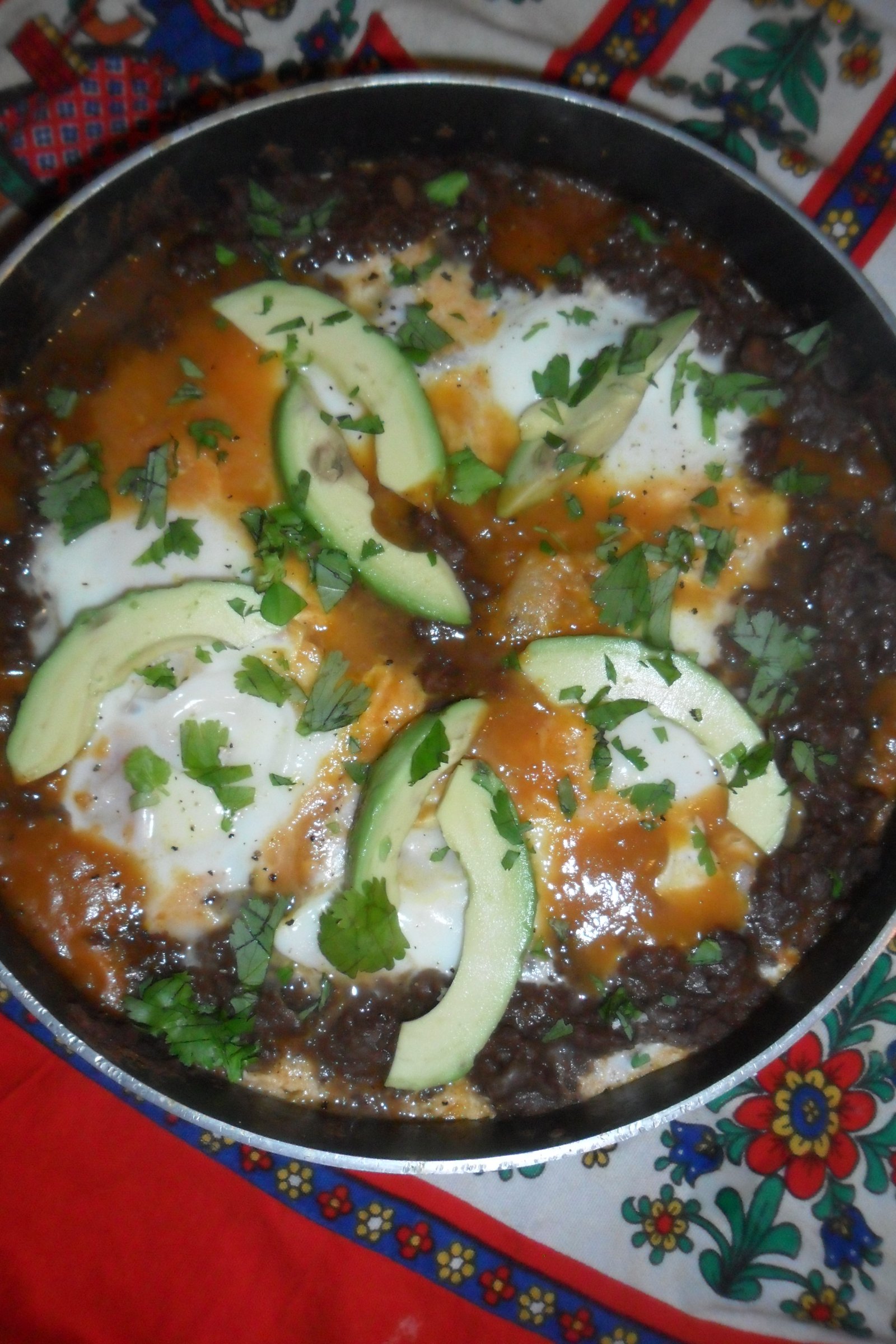 Garnished chilaquiles in pan.