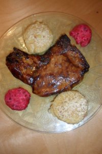 Serving pork chop with polenta and cactus fruit