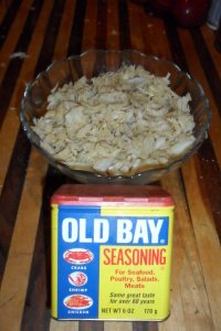 Old Bay spice can with bowl of crab.