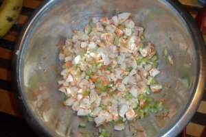 Mixing cooked meat with vegetables.