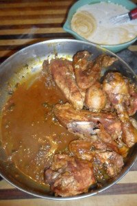 Adding the finished sauce to the pan of chicken.