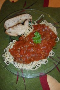 A yummy serving of spaghetti and garlic bread.