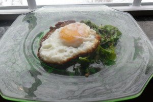 Serving crispy-edged egg on greens.