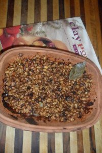 Clay pot of bad beans and cookbook.