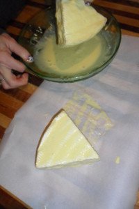 Dipping brie in egg mixture.