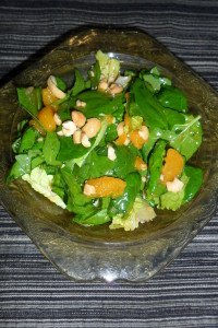 Spinach salad with dressing in a bowl.