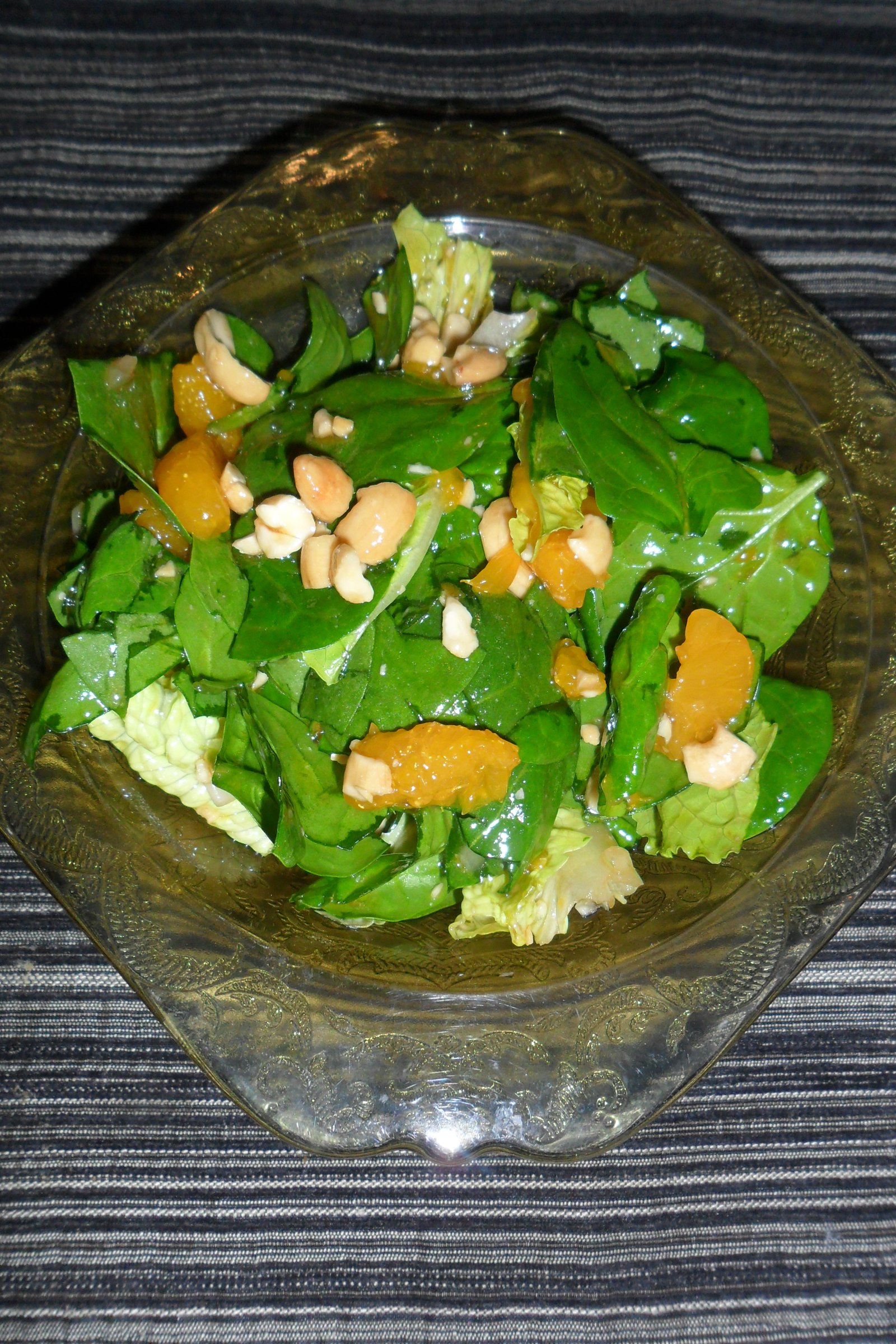 Spinach salad with dressing in a bowl.