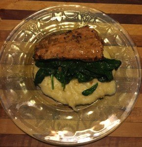 Serving salmon on spinach and polenta.