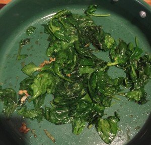 Wilted spinach in pan.