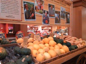 Produce display with farmers' pictures.