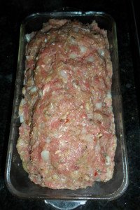 Putting meat mixture in loaf pan.