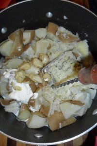 Mixing roasted garlic cloves into potatoes.