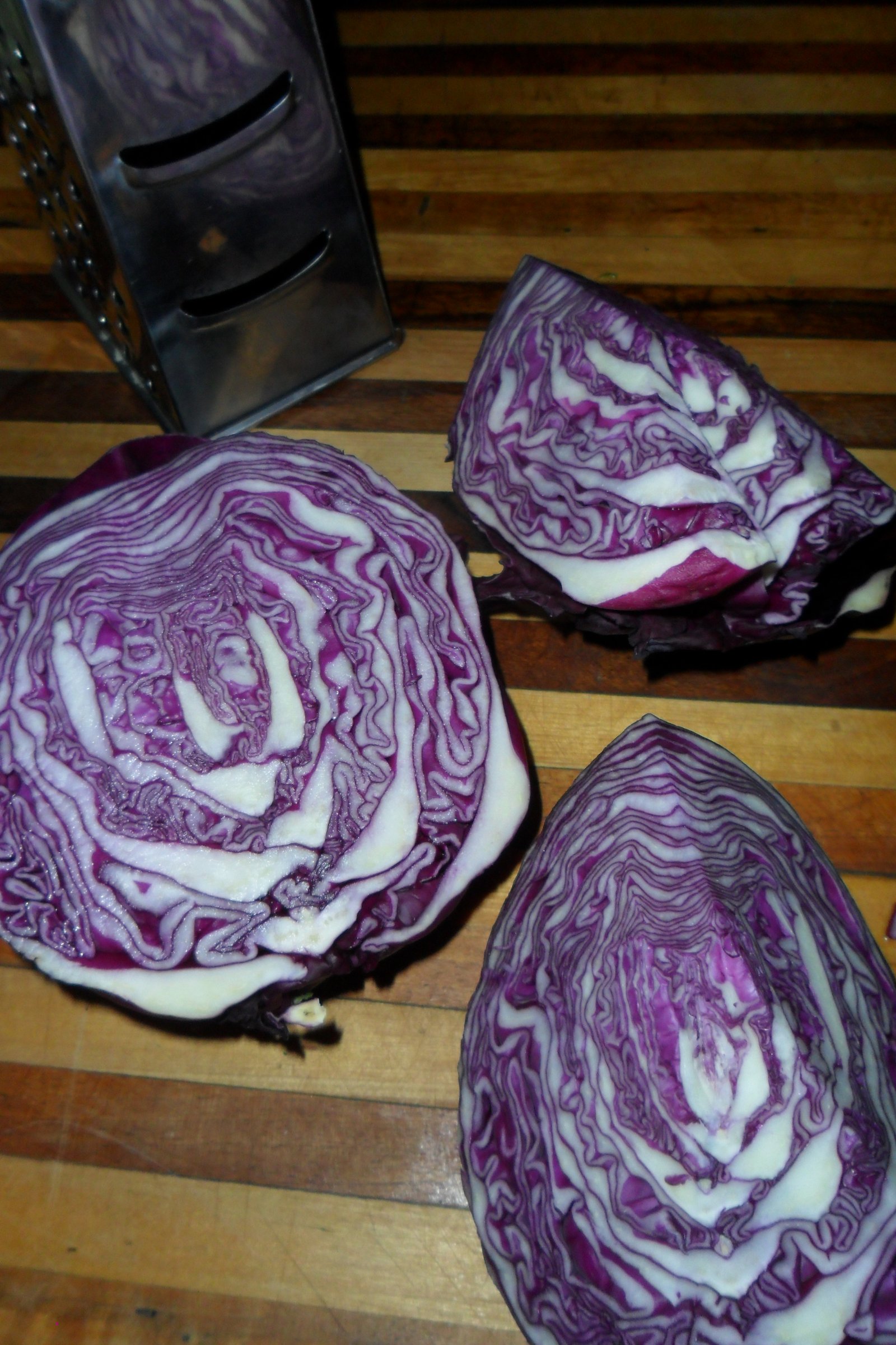 Striped cabbage cut in thirds and the grater.