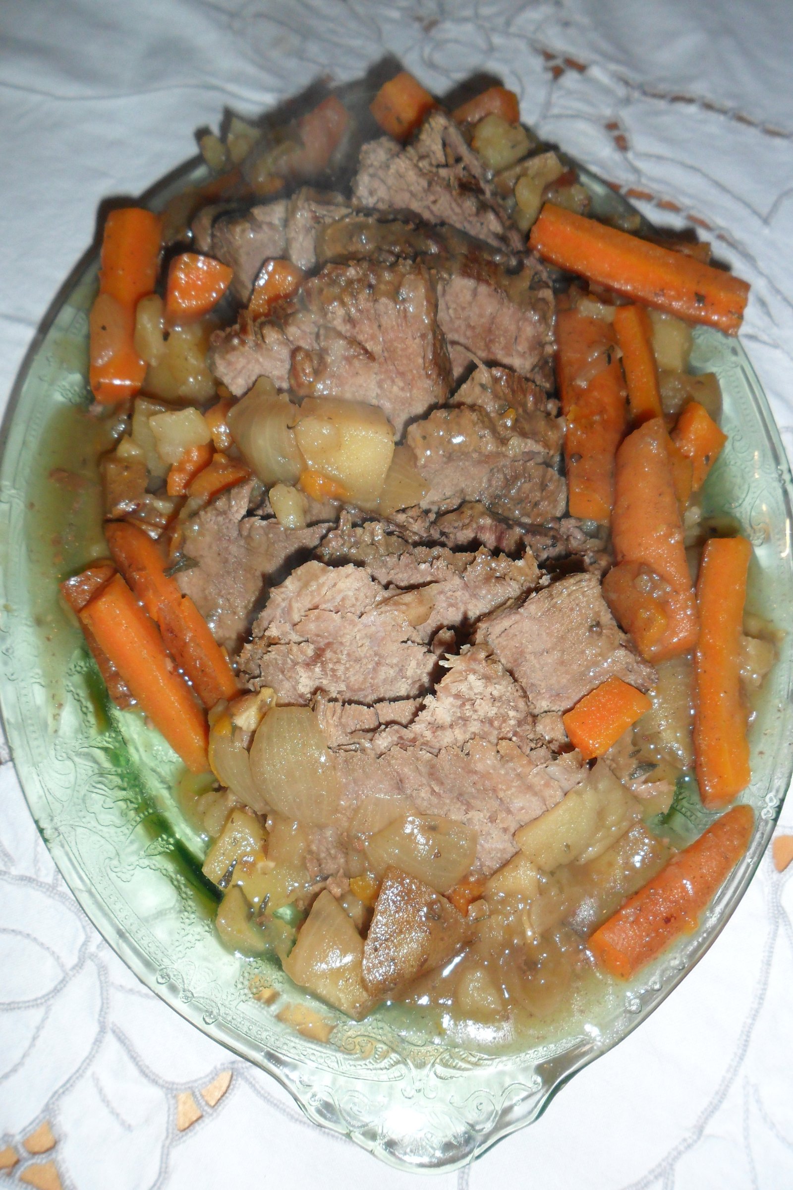 Serving roast on platter surrounded with vegetables.