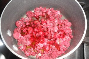 Cooking frozen raspberries with syrup.