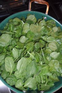 Filling the pan with spinach.