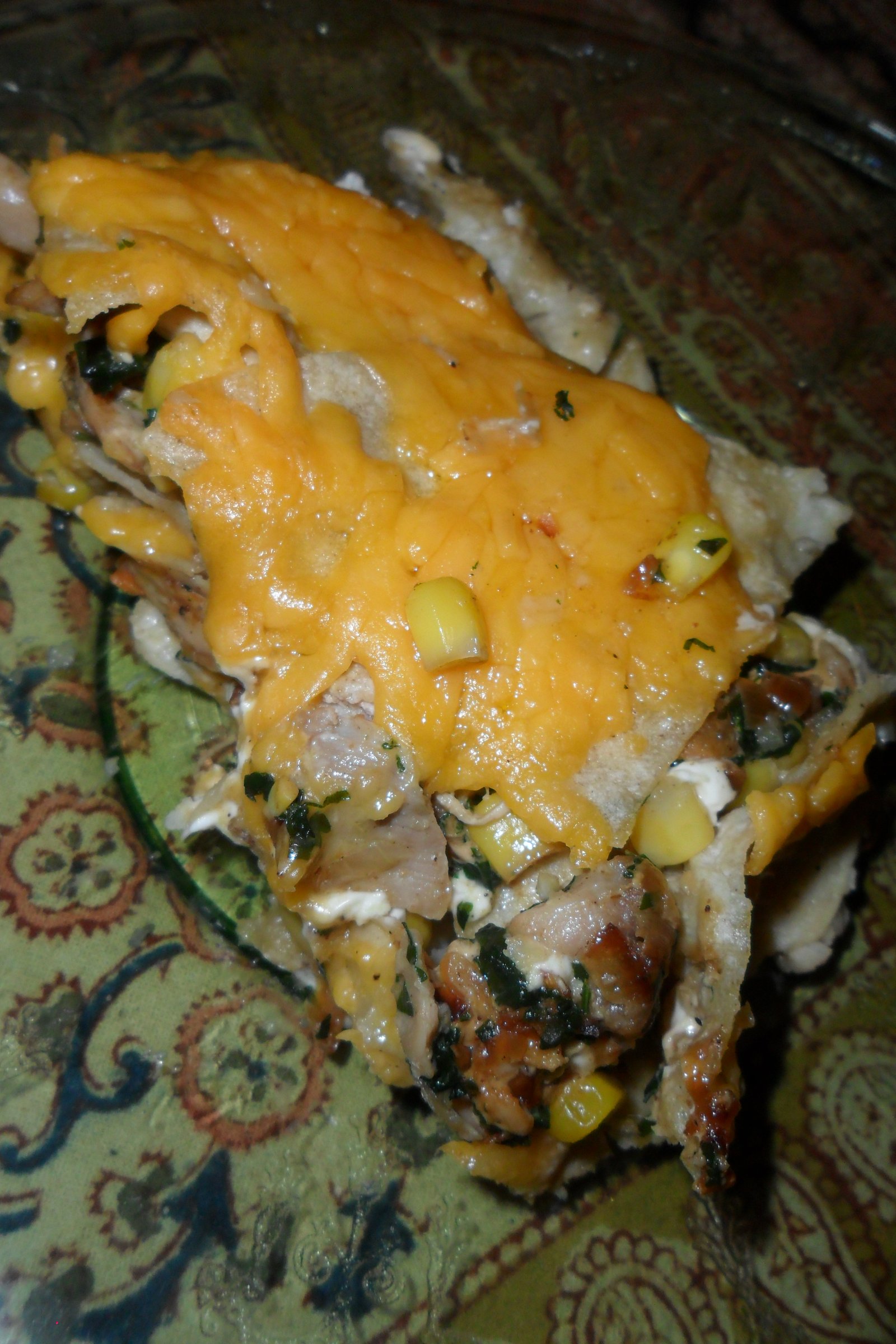 Serving enchilada casserole on clear plate.