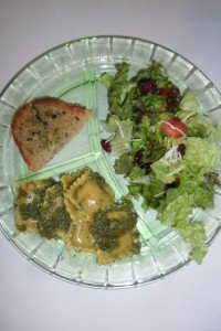 Carrot pesto ravioli served with salad and garlic bread.